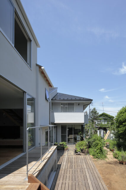 実家のウッドデッキとシームレスにつながる。子どもたちは、毎日のようにここを通って実家と行き来するのだとか。庭には様々な樹々や草花が植えられ、四季折々の楽しさのひとつになっている。