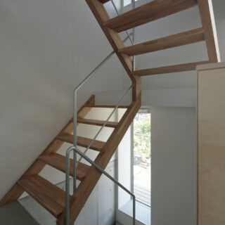 小さな建物の南側は階段スペース。１階から２階は箱階段、それより上は木製のスケルトン階段を採用し、上階からの光を降ろしている。