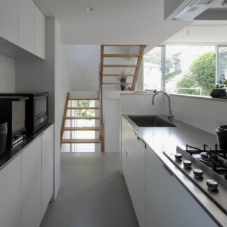 リビングダイニングを見渡せ、その先の景色も楽しめるキッチンは直線的な配置。高圧メラミンを採用し、マットな質感の面材を採用。レンジフードも統一した。