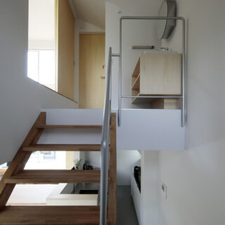 ２階の踊り場には、洗面スペースを。小さな棟の低い勾配天井を巧みに利用し、絶妙な高さを実現した。