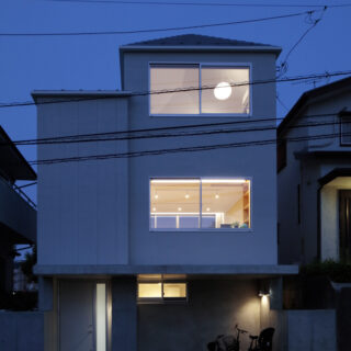 夜になると、RCの土台、大小２つの棟の趣の違いがより一層際立つ。高さがあるため、１階リビングの様子も道路から丸見えにならない。