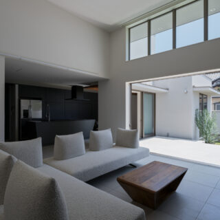 天井の低い玄関から一転、高さ4mの天井、大窓・高窓がもたらす抜群の開放感。まるで高級リゾートのヴィラのような佇まい。