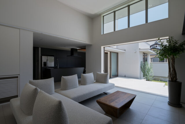 天井の低い玄関から一転、高さ4mの天井、大窓・高窓がもたらす抜群の開放感。まるで高級リゾートのヴィラのような佇まい。