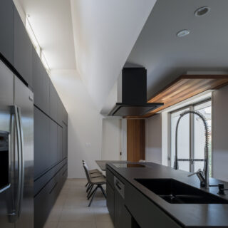 東側に設けられた高窓から、朝日が壁に反射しキッチンを照らす。この窓は、煙突効果により空気の通り道にもなる。キッチンの奥がダイニングゾーン。抜群の動線を実現した。