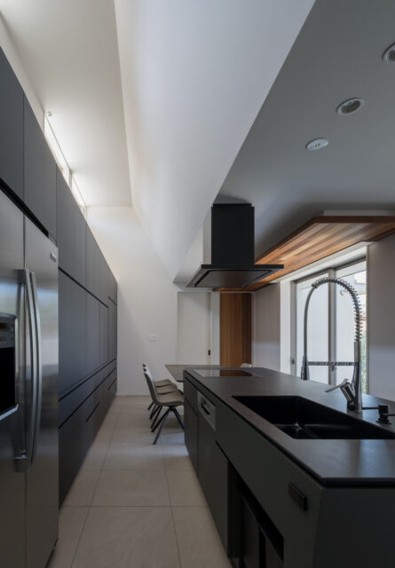 東側に設けられた高窓から、朝日が壁に反射しキッチンを照らす。この窓は、煙突効果により空気の通り道にもなる。キッチンの奥がダイニングゾーン。抜群の動線を実現した。