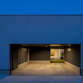 車２台が余裕で納められるガレージ。右奥に、中庭に続く開口を設けている。隣には来客用の駐車スペースも確保した。