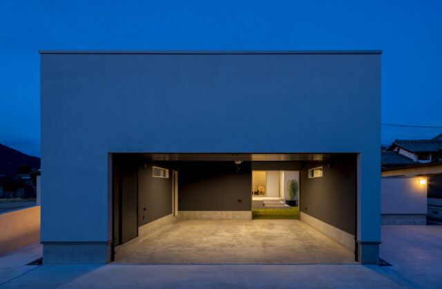 車２台が余裕で納められるガレージ。右奥に、中庭に続く開口を設けている。隣には来客用の駐車スペースも確保した。