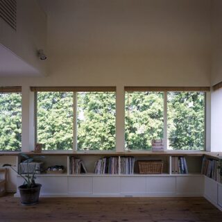 リビングから見える、メタセコイアの並木。2方向の窓すべてから、この緑を楽しむことができる。出窓風の窓の下には、上段がオープンで下段が扉のある収納。道路からの視線をカットする効果もある。窓は引違いの通常サッシだが、サッシ部分に木製の柱を配置することで室内からサッシが見えない
撮影：石黒 守