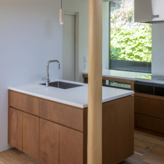 1階は隣地の斜面の緑へも視線が抜けるよう、キッチン側にも窓を設けた