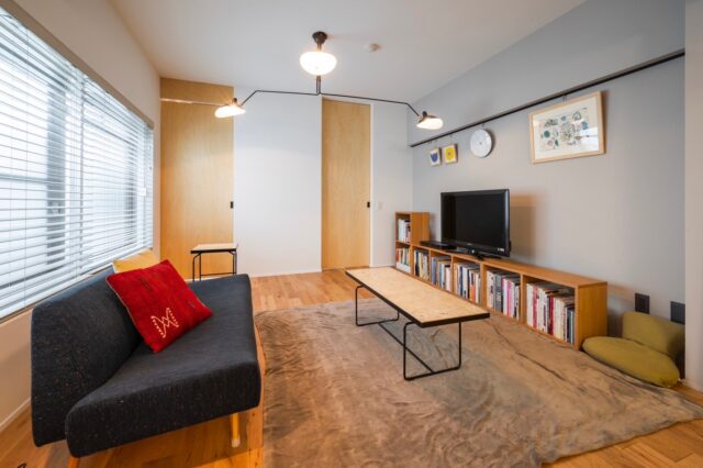 リビング。左に光庭があるため、中央部のリビングも明るい。正面の扉はフルハイトで上から吊り、下に段差はない。扉の枠もなくしたのでスッキリしている。将来の賃貸を考え、照明はあえて引っ掛けシーリングに。入居者が好きな照明を取り付けられるための工夫だ
