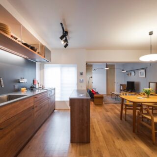 キッチンの高さは標準的な高さより3cm高いものとした。一番手前がキッチンと同じ素材で造作した食洗機置き場。ビルトイン式は故障した時に大変なので、据え置き型を置く前提だ。棚上の照明や水栓は非接触型。キッチンパネルは磁石が付くガルバリウム鋼板を採用した。