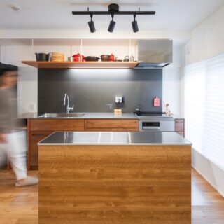 キッチン。IHを採用し、80年代のヴィンテージマンションはオール電化に変貌した。照明だけでなく右側の光庭からも光が入り、明るいレイアウトだ。手前のカウンターは造作に見えるが通販で買ったもので、自由に移動できる。