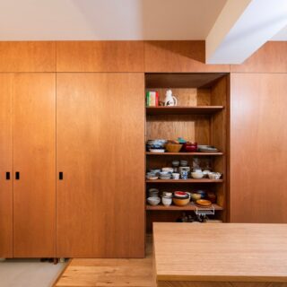 唯一の造作収納。横並びするキッチンの面材と同じラワン合板として統一感を出した。一番左がシューズボックス、右が食器やレンジなどの家電を入れることを想定した。中の棚はすべて同じサイズ。棚の数や間隔を、すべての収納部分で自由に変えられる。