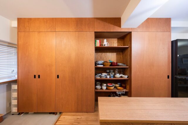 唯一の造作収納。横並びするキッチンの面材と同じラワン合板として統一感を出した。一番左がシューズボックス、右が食器やレンジなどの家電を入れることを想定した。中の棚はすべて同じサイズ。棚の数や間隔を、すべての収納部分で自由に変えられる