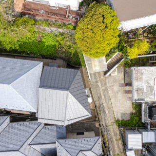 上部から家を見る。家に対して画像上部の北側と、東側から斜線制限による高さ規制がかかるため、切妻屋根と方形屋根を組み合わせ、内部の天井が高くなる面積をより広く確保した