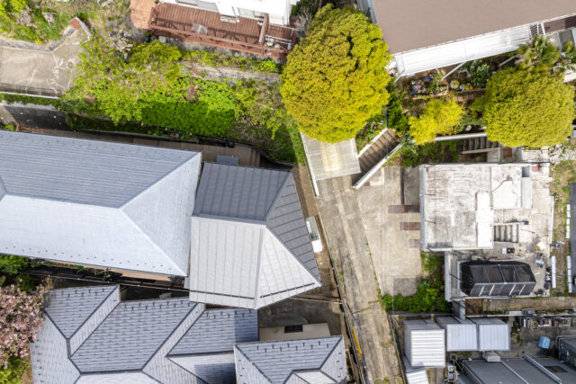 上部から家を見る。家に対して画像上部の北側と、東側から斜線制限による高さ規制がかかるため、切妻屋根と方形屋根を組み合わせ、内部の天井が高くなる面積をより広く確保した