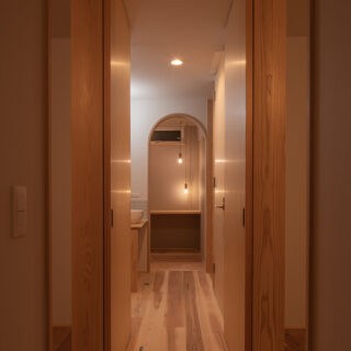 1階廊下の奥はファミリークローゼット。アールの開口やレトロな照明で、収納とは思えない雰囲気を演出