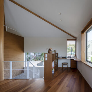2階、リビングから書斎方向を見る。画像左の柱を起点とし、奥は方形屋根、手前は切妻屋根を生かした天井となっている。2つの形を組み合わせることで内部の天井高の変化も豊富になり、おかげでひとつの空間の中に居場所を多く計画できるようになった