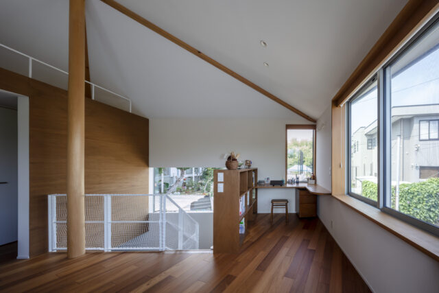 2階、リビングから書斎方向を見る。画像左の柱を起点とし、奥は方形屋根、手前は切妻屋根を生かした天井となっている。2つの形を組み合わせることで内部の天井高の変化も豊富になり、おかげでひとつの空間の中に居場所を多く計画できるようになった