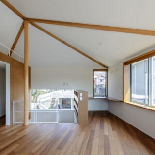 2階。南側の大開口にも緩やかに角度がついているうえ、正面の書斎の細い窓、左に続く階段の窓と方向や高さが異なる窓が並び、移動時に自然に景色や光の雰囲気が切り替わる。表情の異なる明るさと、存分に入る日射による暖かさは五角形の建物の特徴を生かした豊かさのひとつ