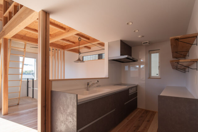 キッチン。写真右に進むとランドリールームがあり、家事動線がとても良い。キッチンは造作より低コストの既製品にして予算調整したが、背後のカウンター収納は薄井さんがデザイン。所有している食器や家電、購入予定のアイテム等をヒアリングし、カスタマイズしてつくっている