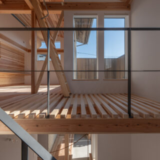 階段からの眺め。ソラドマ（2階バルコニー）に面した大きな窓は、冬に真南の暖かな日射を得るという大役を担っている。手前の床は目透かし板にして、空気の循環や1階の明るさを担保。丁寧な職人技が光る目透かし板はインテリアとしても美しい