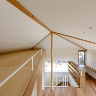 2階をロフトから見下ろす。ロフトは同じ高さで天井高が延びる切妻屋根の下に配置し、一定の高さを確保した。高い部分で1.2ｍ程あり、使いやすい。遊びにいらしたお孫さまたちがここで寝られることもあるとのこと