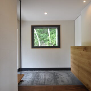 玄関。太めの枠で囲った窓が、白樺を絵画のように引き立たせる
