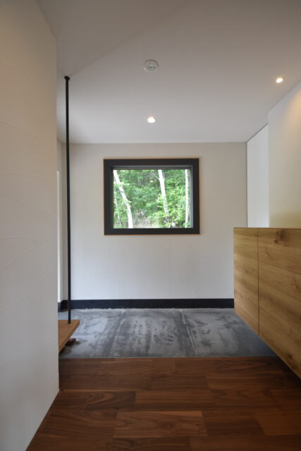 玄関。太めの枠で囲った窓が、白樺を絵画のように引き立たせる
