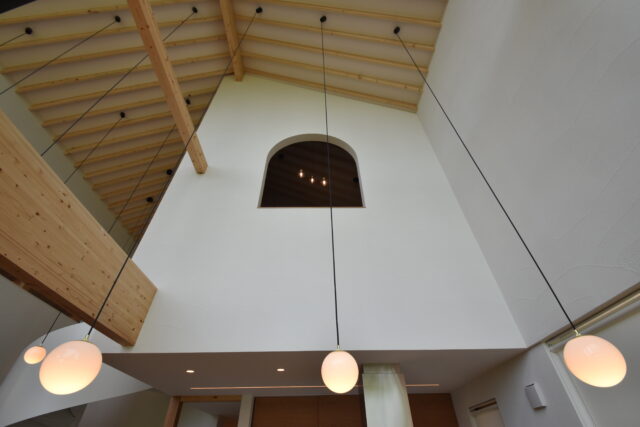 1階LDKから2階寝室を見上げる。寝室の小窓にも中島の稜線と調和するアールをつけた
