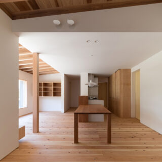 玄関土間からLDKを見る。右壁面の引き戸は勝手口や階段、洗面・脱衣室に繋がる。隠れているが続く収納の奥にも引き戸があり洗面・脱衣室と繋がる。天井を設けたキッチン、ダイニングに比べリビングや土間は天井が高く、感覚的にエリアが区切られ過ごしやすい