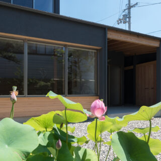 庭から「庭を眺める窓」とテラスを見る。立面的なバランスを考え、窓を出すのではなく奥まらせ、その幅を活用し庇の役目を持たせた。ジョリパットの質感豊かな黒い塗壁と木材の表情を見せた外観はメリハリが効いており美しい