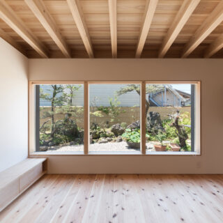 キッチン、ダイニングからリビング、「庭を眺める窓」を見る。庭をより美しく見せるため、FIX窓を採用。サッシやロックなどを一切見せず、すっきりした印象に仕上げた。枠に厚みを持たせることで視界の広がりを抑え、絵画のように庭の景色を切り取った