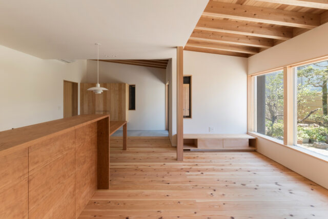 キッチン（左手前）ダイニング（左奥）、リビング（右）。室内のどこにいても庭が魅力的に見える。床は杉の無垢材を、壁や天井には漆喰を採用した。自然素材に満ちた空間に溶け込んだ庭の景色が四季折々で胸に響く