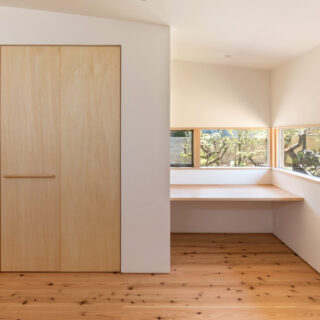 1階夫妻の寝室。庭は南側にあり、日当たりのよい右のカウンターで奥さまが日本画を描かれる。印象的に見せるため、意図的に細く景色を切り取ったと樋口さん。左壁面に設けた収納は着物や布団を収納するため、奥行きを深く計画した