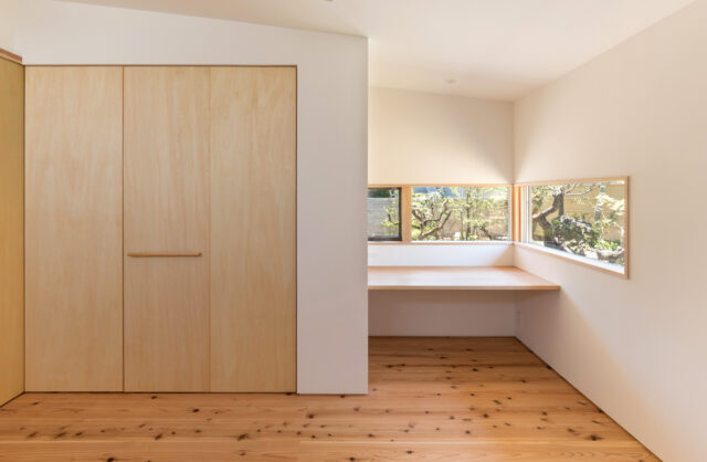 1階夫妻の寝室。庭は南側にあり、日当たりのよい右のカウンターで奥さまが日本画を描かれる。印象的に見せるため、意図的に細く景色を切り取ったと樋口さん。左壁面に設けた収納は着物や布団を収納するため、奥行きを深く計画した