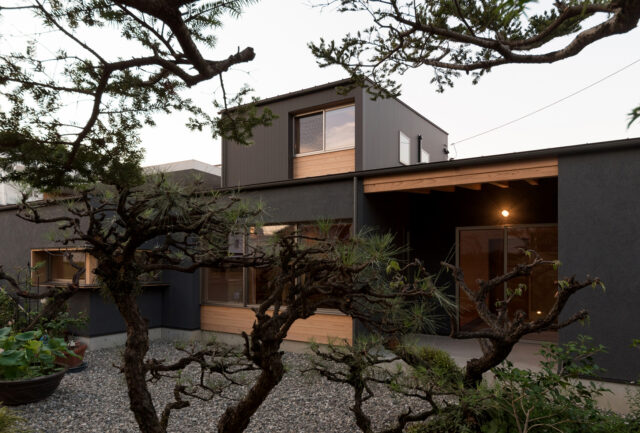 庭から家を見る。画像右、半屋外のテラスは土間と一続きになっており外に出やすい。キッチンからも近く、食事を楽しまれたりしているとのこと。建て替えにあたり、庭をどう残すかにも心を砕いたという樋口さん。植栽を増やしたり、砕石を敷いたりして整えた