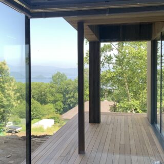 1階浴室からテラスを見る。屋根があるテラスは天候関係なくくつろげる。左隣で暮らす義理のご家族とも、ここで交流することがあるのだとか。浴室は要望からブルーで仕上げた。絶景のお風呂はお施主さまもお気に入りの場所の1つ