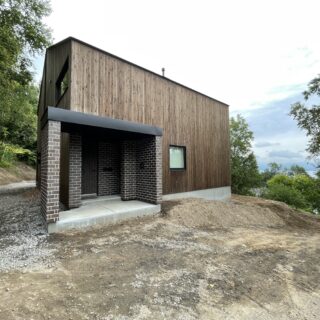 外観。ご要望に応え取り入れた落ち着いた色のレンガが、景色と溶け込む感覚を強めている。家は、洞爺湖の眺めを優先し、敷地の中でも一番高い場所に配置した