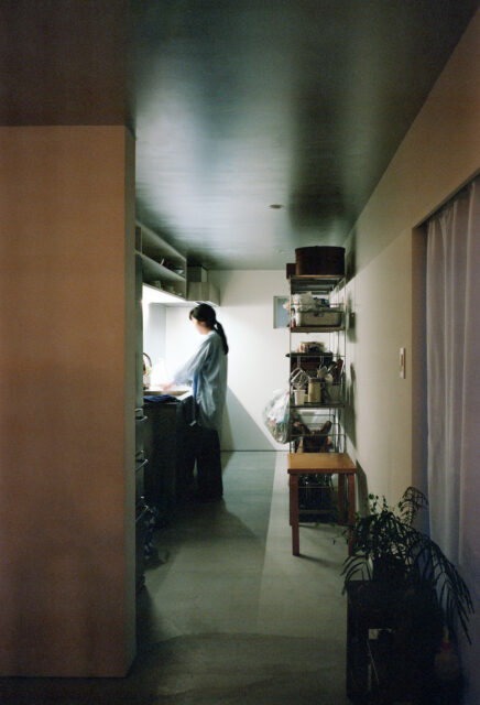 ホールの先のキッチンは領域を分かりやすく独立したイメージに。システムキッチンを採用しつつ、棚はあえてつくりつけとせず、可変性をもたせた。