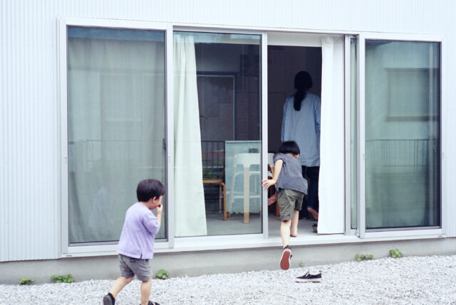 正面の大窓を縁側のように使い、外からの出入りをするなど、昔懐かしい子どもの姿でのびのびと遊んでいる兄弟。