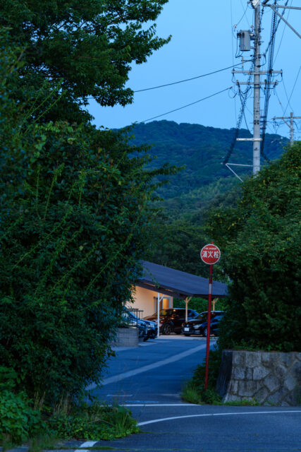 集落の入口となる道路から見た光景。片流れの低い屋根の効果で、その先に山などの景色を見ることができる