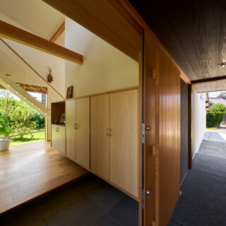 玄関アプローチ、玄関、室内。玄関アプローチの天井高を抑え、吹き抜けの室内の開放感との対比を強調した
