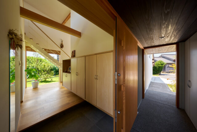 玄関アプローチ、玄関、室内。玄関アプローチの天井高を抑え、吹き抜けの室内の開放感との対比を強調した

