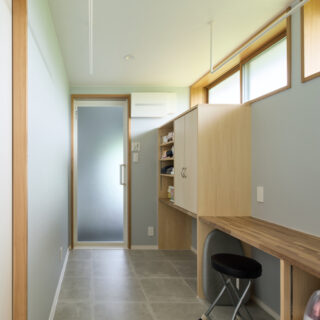 浴室（正面奥）へつながる脱衣所は、ランドリースペースと家事コーナー、衣類の収納スペースを兼ねている。ハイサイドライトの効果で明るい空間だ。左手前のドアは寝室につながっており、効率的な動線が考えられている