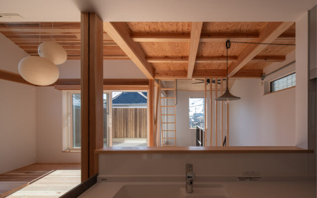 キッチンからの眺め。リビング（写真左側）、ダイニング（写真右側）、ソラドマ（バルコニー）までを見渡せる上、写真右奥にある階段をのぼってくる家族の姿も目に入る。「家事をしながら子どもを見守れる」という要望にパーフェクトに応えたレイアウトだ