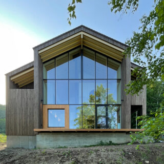 洞爺湖側から見た外観。国立公園内にあるため、外観は茶やネイビーなどの規定もあり、屋根は流れにしなくてはならない。日野さんは切妻屋根に木材の柄も引き立つブラウンの壁を選択。下部のRC部分は杉板型枠を使用し板柄とし自然に溶け込ませた。窓の左下は読書スペースにあたる