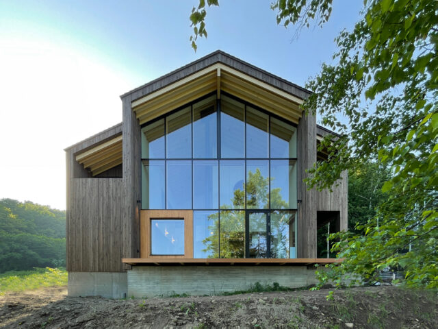 洞爺湖側から見た外観。国立公園内にあるため、外観は茶やネイビーなどの規定もあり、屋根は流れにしなくてはならない。日野さんは切妻屋根に木材の柄も引き立つブラウンの壁を選択。下部のRC部分は杉板型枠を使用し板柄とし自然に溶け込ませた。窓の左下は読書スペースにあたる