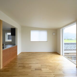 2階LDK。ダイニングリビング空間は、屋根に合わせ勾配天井とした。キッチンの裏に大容量のパントリーを設けてあるおかげで、キッチンはいつでもきれいに整えることができる。