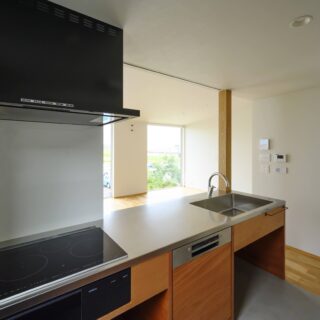 2階、キッチンはご要望から収納をご自分で計画できるよう、棚などを省き空間を空けた。作業台はフラット。立ち上がりによる感覚的な線引きが軽減され、LDKが丸ごと一つになり、外の風景へと意識が自然に伸びるようになった。